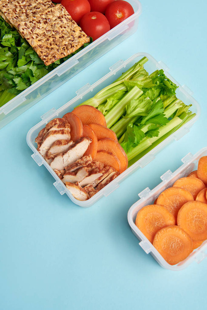 vista ravvicinata della disposizione dei contenitori alimentari con verdure fresche sane e carne isolata su blu
 - Foto, immagini