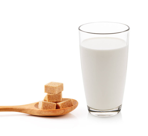 vaso de leche y cubos de azúcar de caña aislados sobre fondo blanco
 - Foto, imagen