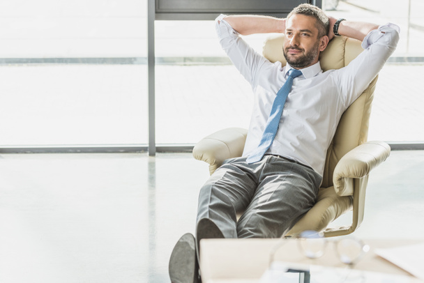 handsome businessman relaxing on luxury armchair at modern office - Photo, Image