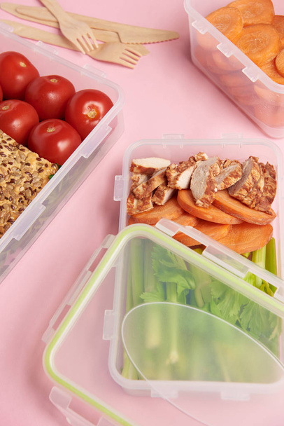 zár megjelöl kilátás az egészséges élelmiszer élelmiszer konténerek a rózsaszín háttér rendezett - Fotó, kép