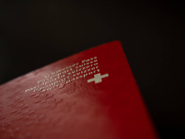 pasaporte suizo de cerca sobre fondo negro aislado ciudadanía suiza
 - Foto, imagen