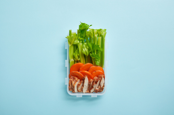 Draufsicht auf Lebensmittelbehälter voller gesunder Mahlzeiten isoliert auf blauem Grund - Foto, Bild