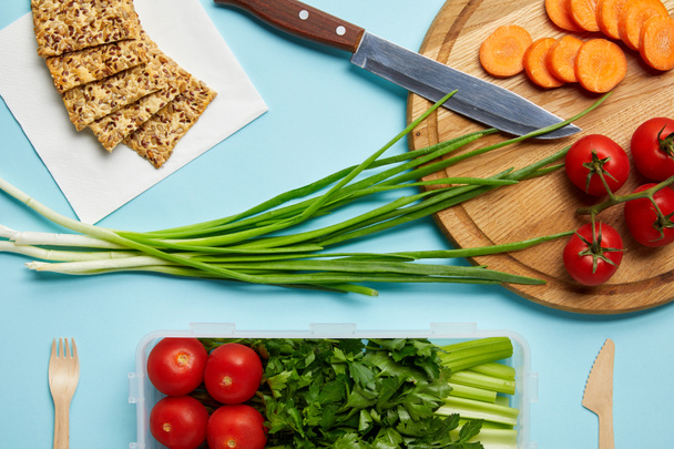 leigos planos com faca e composição saudável de alimentos isolados em azul
 - Foto, Imagem