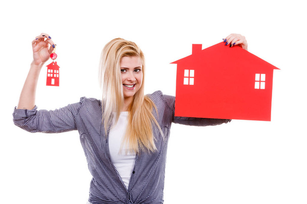 Mülkiyet ve mülkiyet kavramı. Yeni eve taşıdıktan kırmızı kağıt ev ve anahtarları tutan mutlu kadın. - Fotoğraf, Görsel