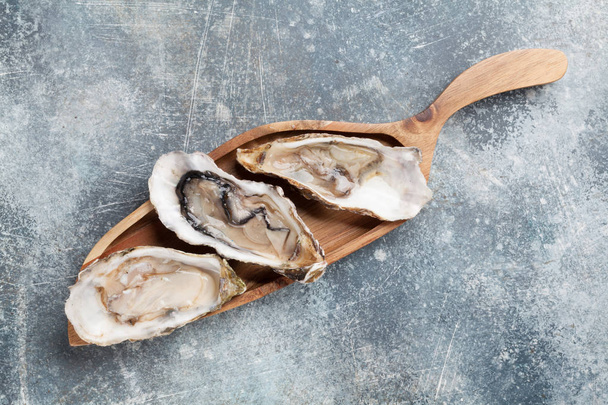 Verse oesters op stenen tafel. Bovenaanzicht - Foto, afbeelding