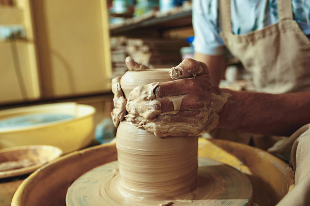 Creating a jar or vase of white clay close-up. Master crock. Man hands making clay jug macro. - Fotó, kép