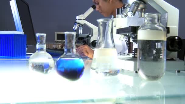 Medical professional working in lab with microscope - Video