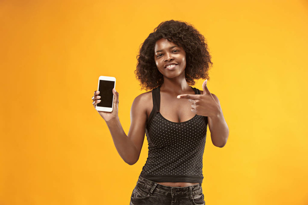 Portrait of a confident casual afro girl showing blank screen mobile phone - Fotoğraf, Görsel