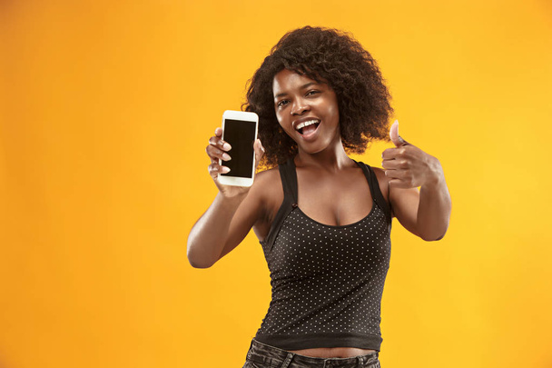Portrait of a confident casual afro girl showing blank screen mobile phone - Foto, immagini
