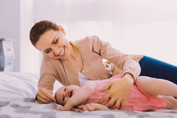 Young businesswoman relaxing with her baby while being at home - Foto, Imagen