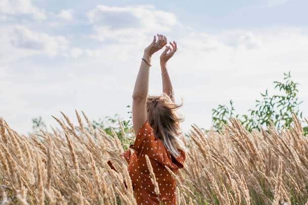 Веселая красивая молодая женщина развлекается и позирует на поле на закате
 - Фото, изображение
