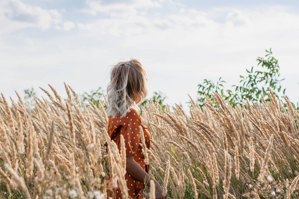 Eğleniyor ve sahada günbatımında poz neşeli güzel genç kadın - Fotoğraf, Görsel