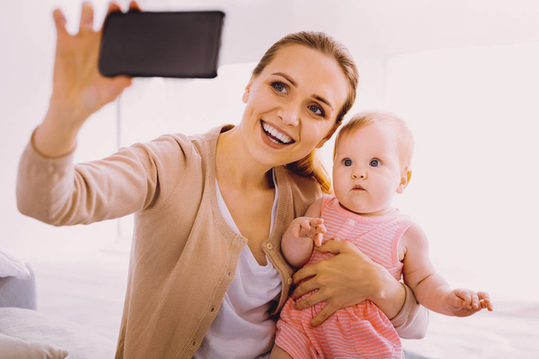 Funny baby looking surprised while seeing a modern device - Fotografie, Obrázek