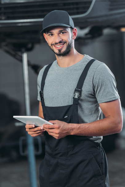 professional auto mechanic in overalls using digital tablet - Photo, Image