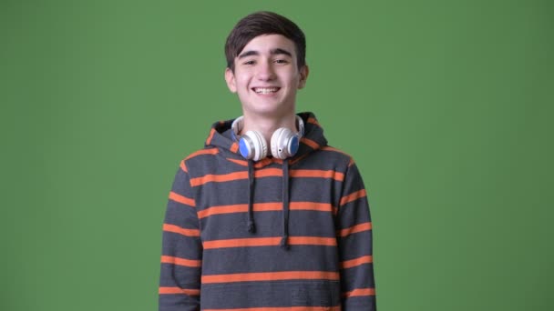 Mladý pohledný íránské dospívající chlapec proti zeleným pozadím - Záběry, video