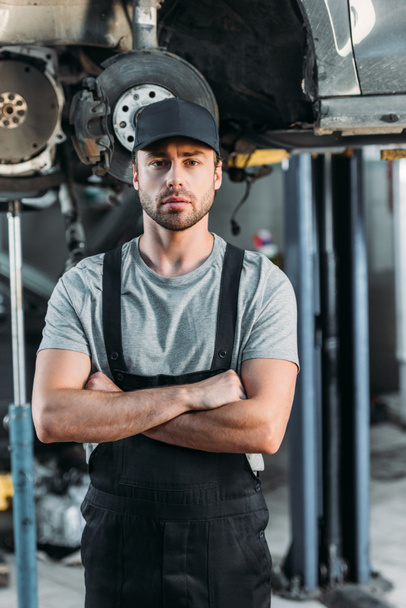 serious mechanic posing with crossed arms in auto repair shop - Φωτογραφία, εικόνα