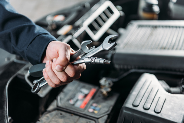 cropped view of mechanic holding wrenches in hand - Photo, Image