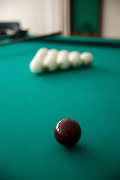 Cue ball for Russian billiards on the table. White billiard balls on the background. Green cloth. Selective focus. - Foto, immagini