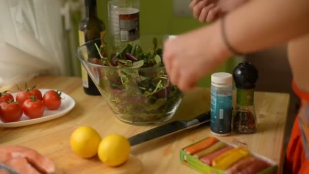 Detail v mělké hloubky ostrosti na stůl kde citron citron lososový sýr a rajčata dívka doma připravuje salát greeny - Záběry, video
