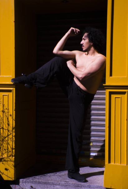 Bailarín latino posando con figuras danzantes. Fondo urbano
 - Foto, Imagen