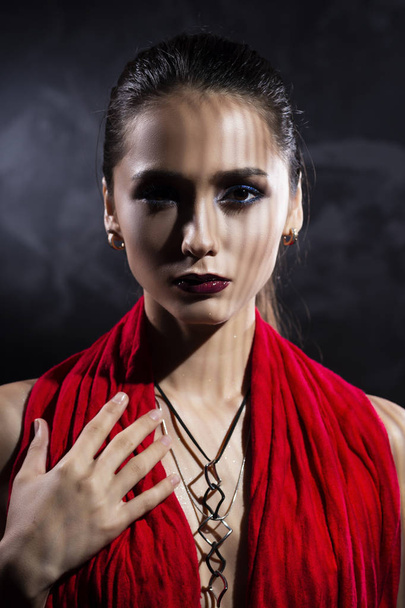 Beautiful brunette topless girl model, covering her naked breast with a red scarf and wearing a modern necklace on the deep decollete. Copy space. Advertising and commercial design. Healthy clean skin - Foto, afbeelding