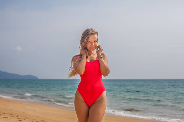 seksikäs nainen punaisessa uimapuvussa rannalla
 - Valokuva, kuva