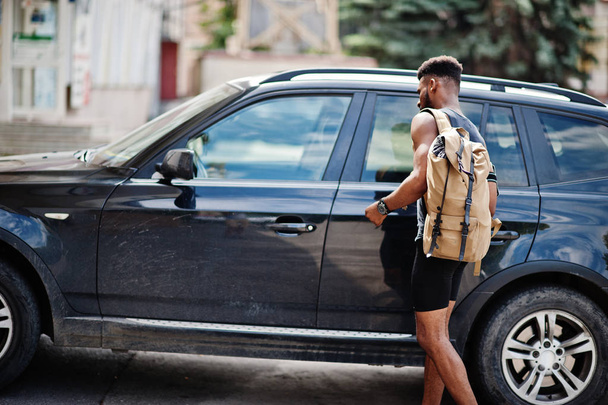 African american male athlete sport man with backpack against his black suv car before training. - Foto, imagen
