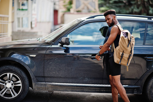 African american male athlete sport man with backpack against his black suv car before training. - Фото, изображение