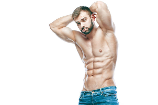 bodybuilder posing. Beautiful sporty guy male power. Fitness muscled in blue jeans. on isolated white background. Man with muscular torso. Strong Athletic Man Fitness Model Torso showing six pack abs - Photo, image
