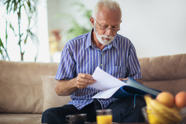 Senior man checking home finances. - Fotó, kép