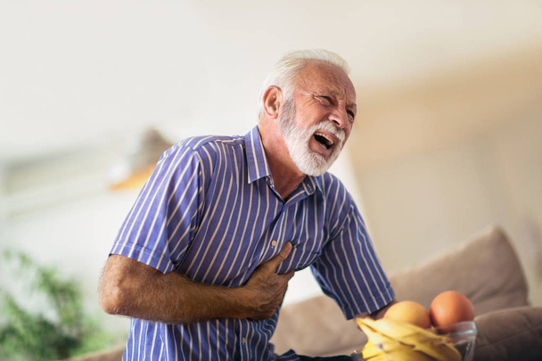 Homem idoso que sofre de ataque cardíaco em casa
 - Foto, Imagem