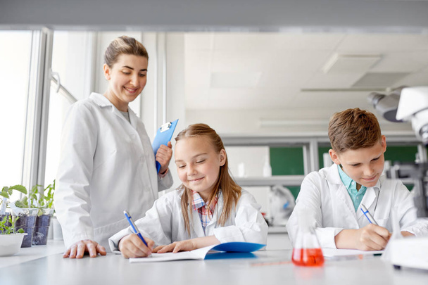 teacher and students studying chemistry at school - Valokuva, kuva