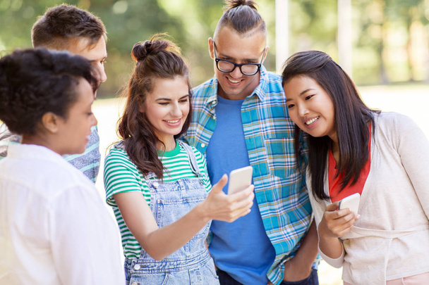 Gruppe glücklicher Freunde mit Smartphone im Freien - Foto, Bild