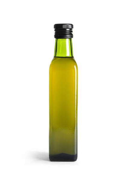 Glass bottle with fresh olive oil on white background - Фото, зображення