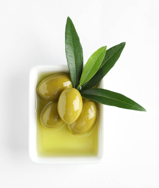 Bowl with fresh olives in oil on white background, top view - Photo, Image