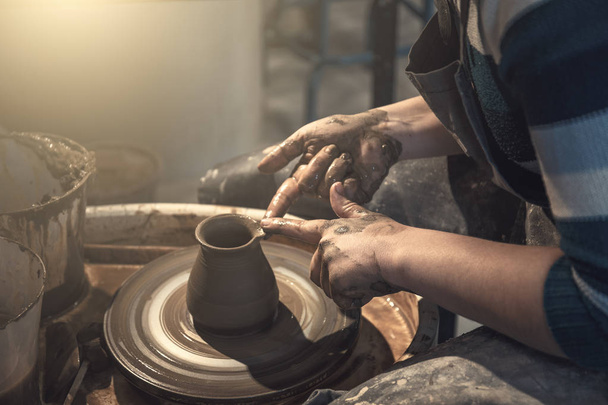 Alfarero hembra trabaja con arcilla en la rueda de cerámica, manos de artesano de cerca
 - Foto, Imagen