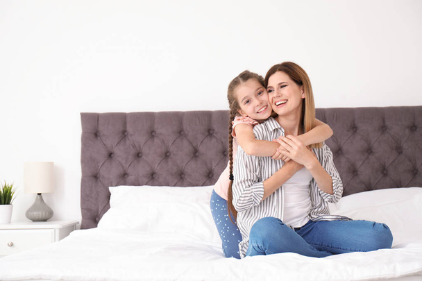 Mother with cute child in bedroom. Happy family - Fotó, kép
