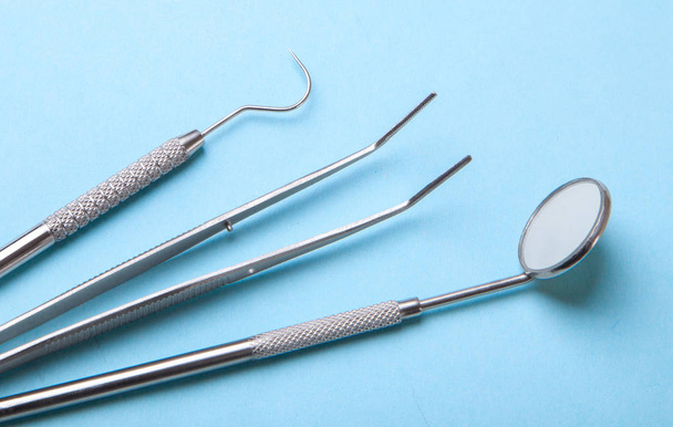 Instrumenty stomatologiczne. Lusterko dentystyczne, sonda hak, pęsety, na niebiesko - Zdjęcie, obraz