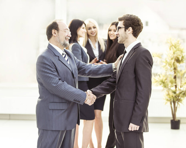 handshake colleagues in the spacious lobby of the office - Foto, imagen