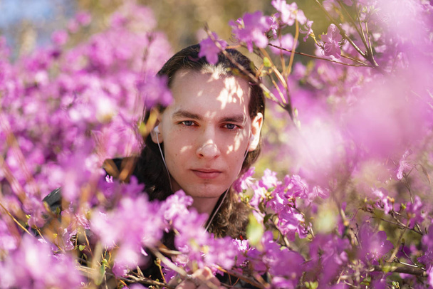 Romantický chlap si přijde v zahradě s růžovými květy rododendronů stromu - Fotografie, Obrázek