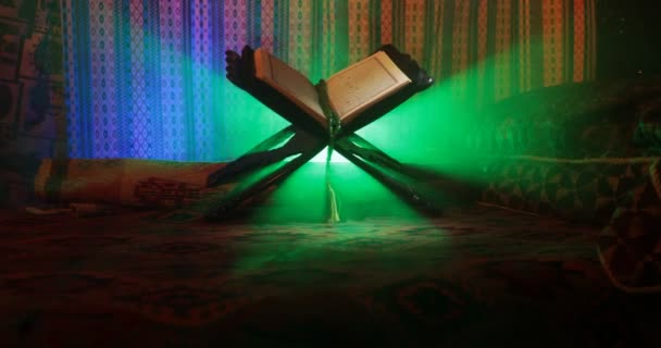 Откройте священную книгу мусульман, стоящих на восточном ковре с темным туманным фоном. Концепция мусульманской религии. Выборочный фокус. Слайдер
. - Кадры, видео