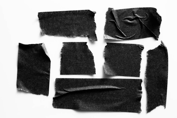 Set of black tapes on white background. Torn horizontal and different size black sticky tape, adhesive pieces. - Foto, immagini