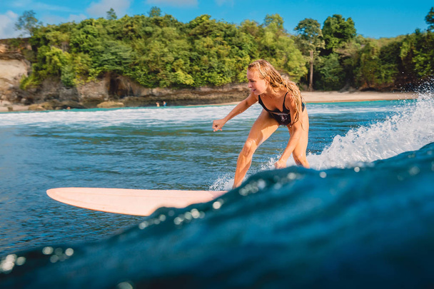 Hermosa chica surfista en tabla de surf. Mujer en el océano durante el surf. Surfista y ola
 - Foto, Imagen