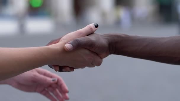 biały dama ręce, trzymając dłoń czarnego człowieka. Miłość, wielokulturowym - powolny ruch - Materiał filmowy, wideo