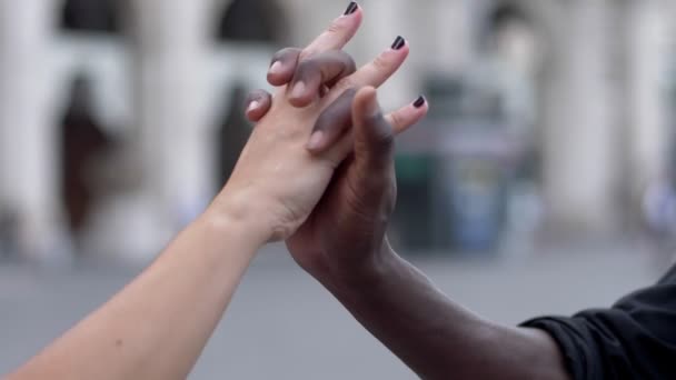Nahaufnahme der interrassischen Liebe weiße Frauenhand, die sich mit schwarzer Männerhand-Zeitlupe verflechtet - Filmmaterial, Video