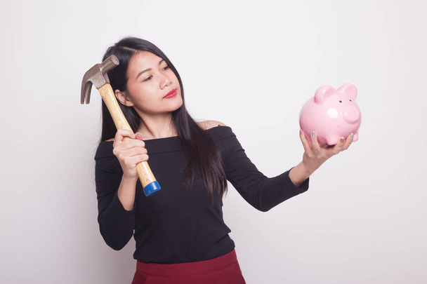 Asian woman with pig coin bank and hammer on white background - Foto, Imagem