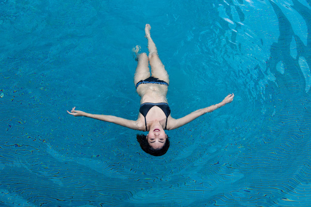сексуальная азиатка в плавательном номере, размещающая водный бассейн. Расслабьтесь в концепции праздника
 - Фото, изображение