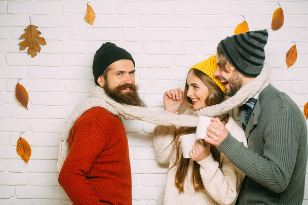 Happy friends at autumn leaves in scarf and hat. - Foto, immagini