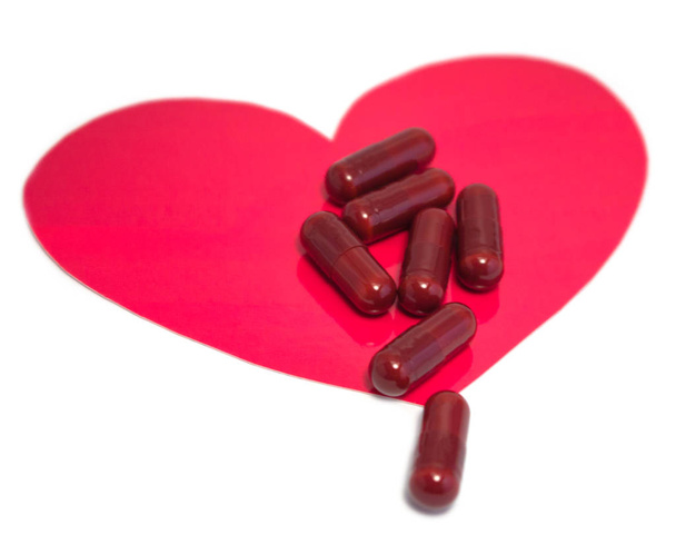 Medical capsules and heart image on isolated white background - Foto, immagini