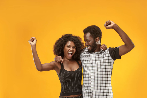 Winning success couple celebrating being a winner. Dynamic energetic image of afro models - Foto, immagini
